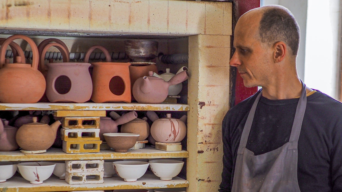 Töpfer begutachtet Hagi-yaki Ware am Brennofen — traditionelles Keramikhandwerk, UNEARTHED Gallery