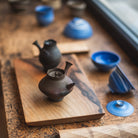 Tea set with teapots and blue cups on a wooden surface