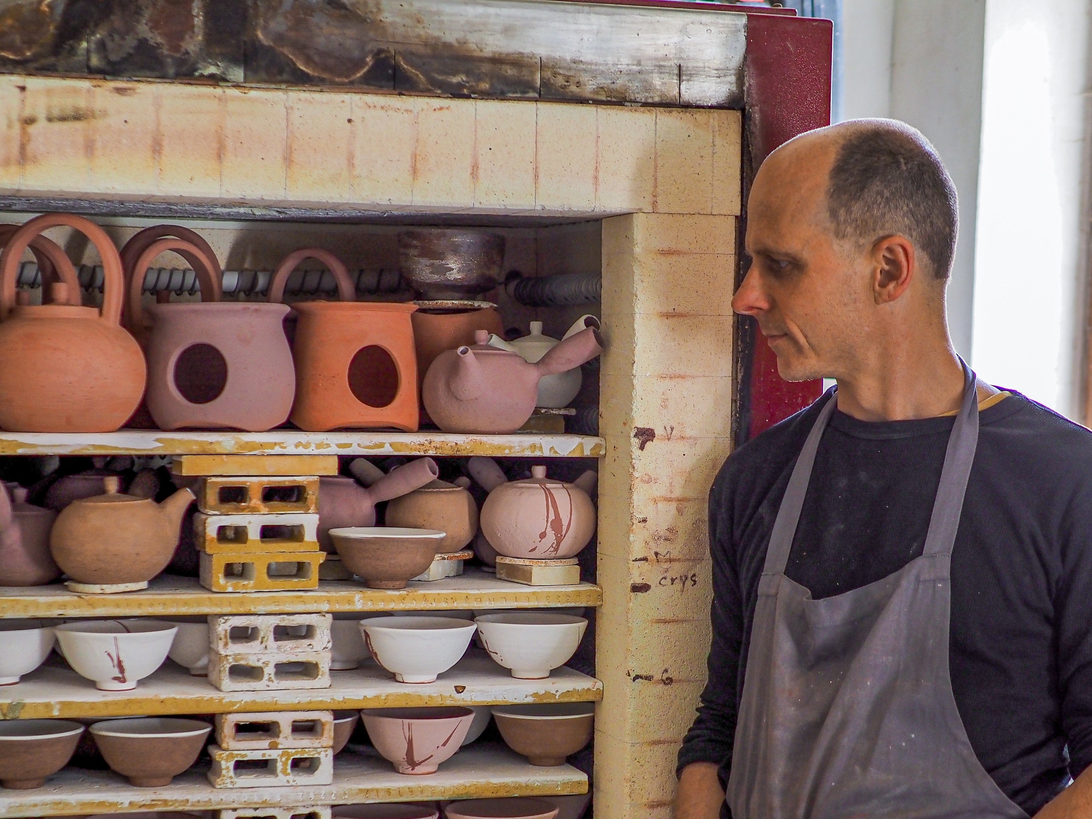 Töpfer begutachtet Hagi-yaki Ware am Brennofen — traditionelles Keramikhandwerk, UNEARTHED Gallery