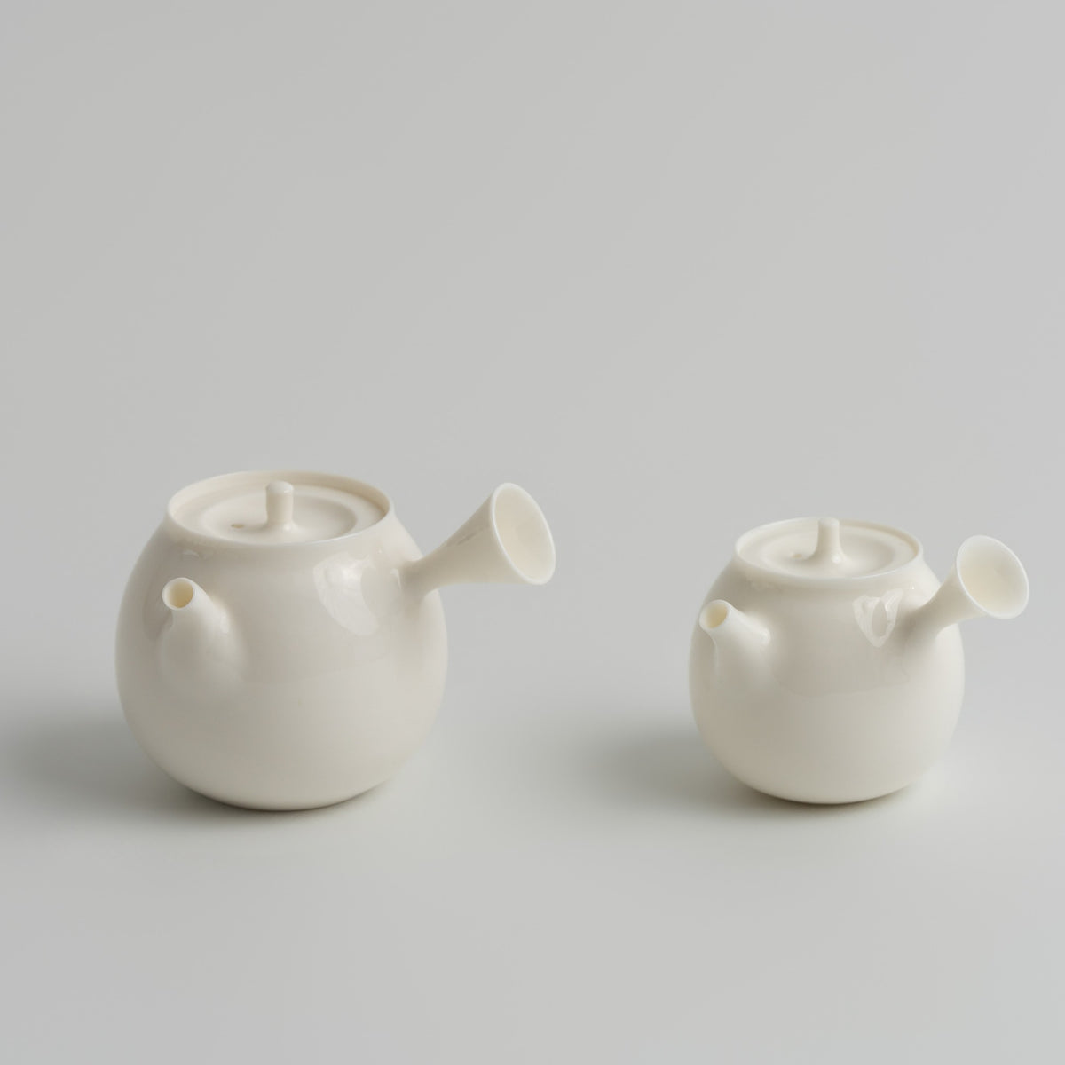 白乳 Bairu Side-Handle Teapot teapot, regular size and 50 ml mini side by side, Buchangqi Studio, Dehua porcelain, UNEARTHED Gallery München