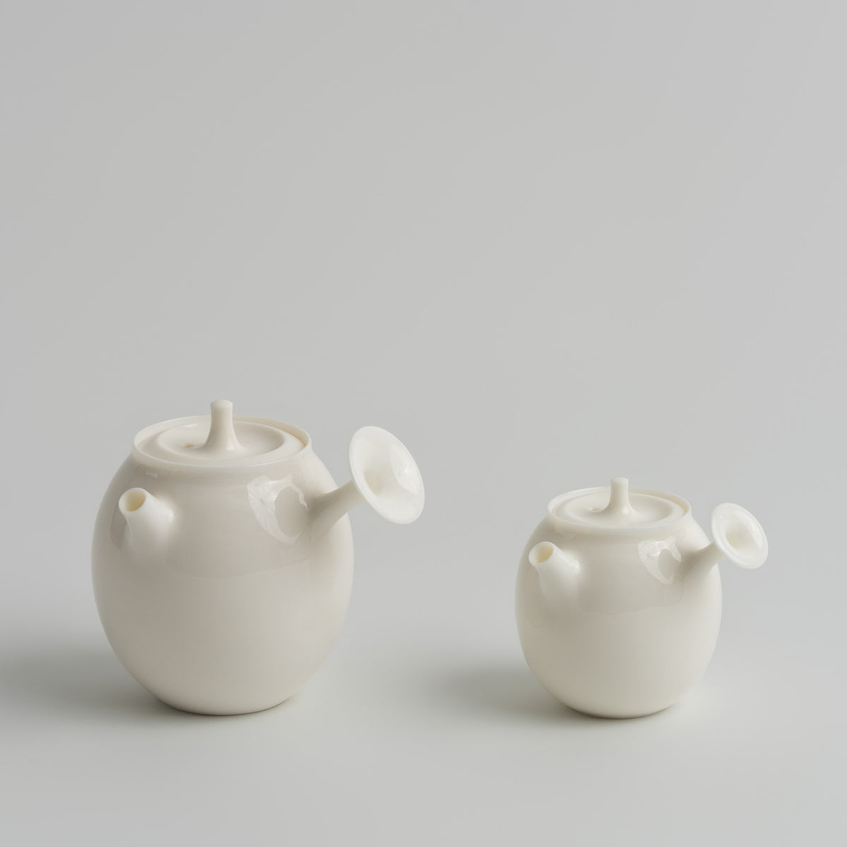 谷帘 Gulian Side-Handle Teapot teapot, regular size and 50 ml mini side by side, Buchangqi Studio, Dehua porcelain, UNEARTHED Gallery München