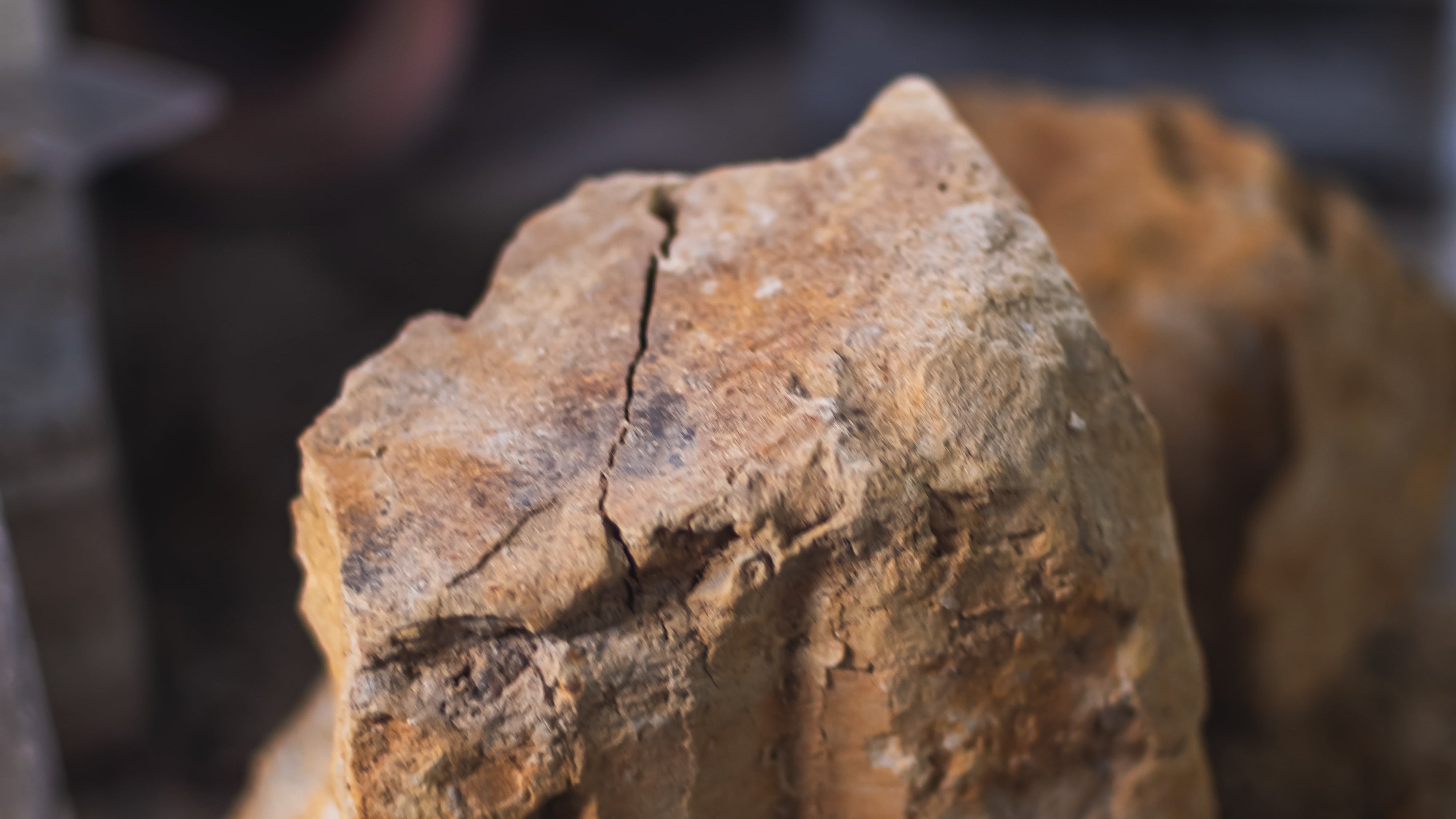 Close-up of a rough-textured clay chunk on a dark surface