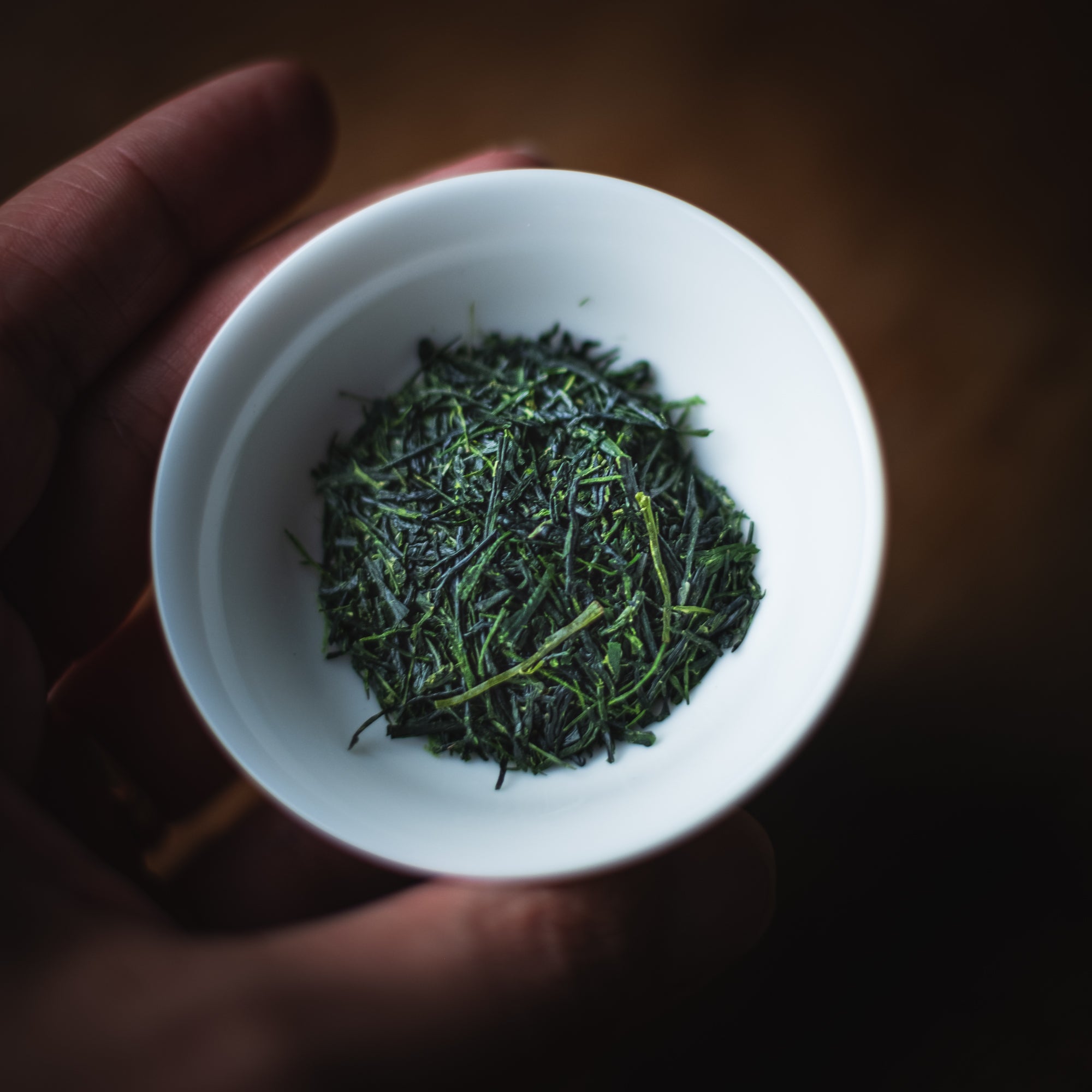 A cup of Hoshino Hon Gyokuro Zairai dry leaf held in the hand