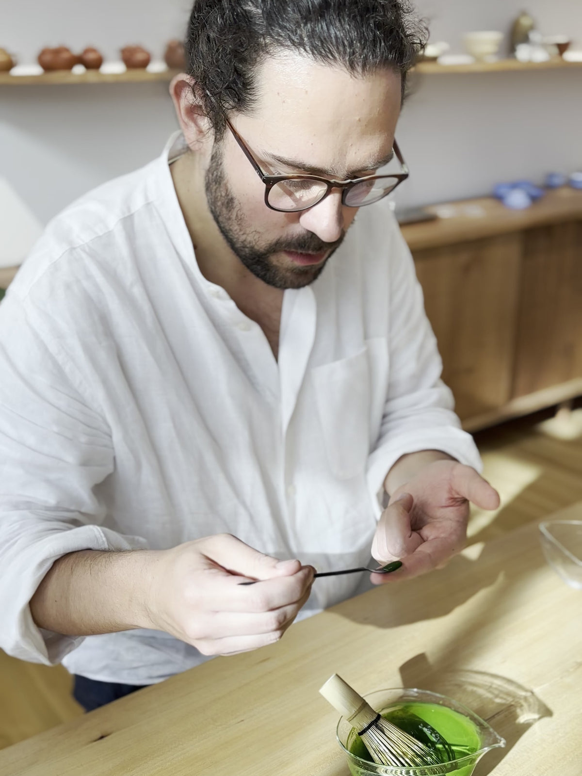 Marcel Karcher examining freshly whisked matcha on a chashaku at UNEARTHED gallery in Munich