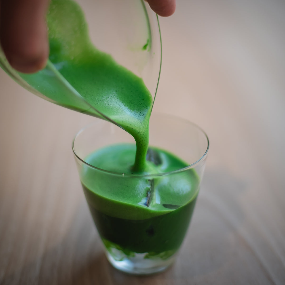 Marcel Karcher pouring freshly whisked matcha from a glass katakuchi into a glass at UNEARTHED in Munich